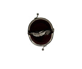A small round silver-tone coin purse with a dark red velvet interior, shown open on a plain light gray background.